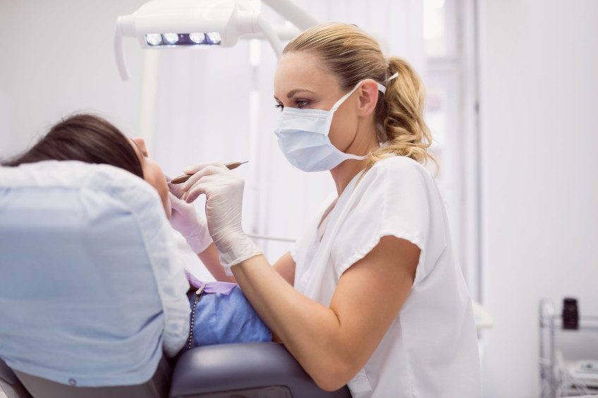 dentist-examining-female-patient-min