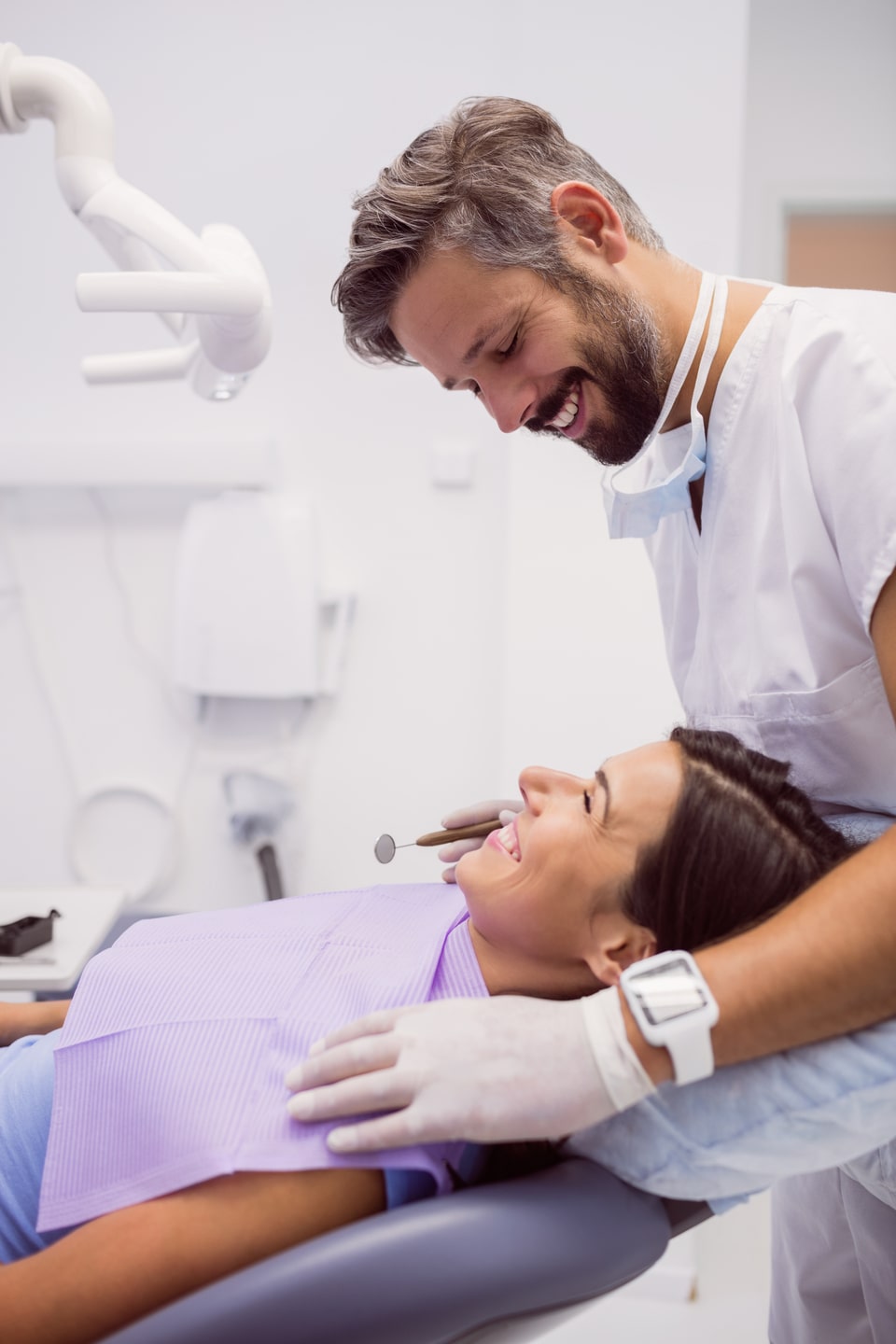 dentist-smiling-while-examining-patient-min